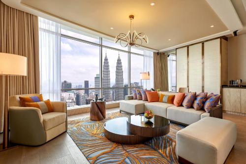 a living room with a couch and a large window at Banyan Tree Kuala Lumpur in Kuala Lumpur