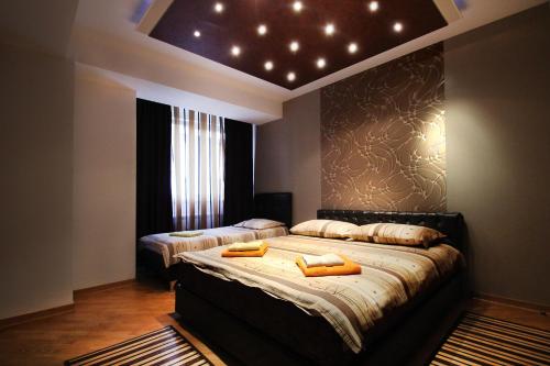 a bedroom with two beds and a ceiling with lights at Apartments Belgrade in Belgrade