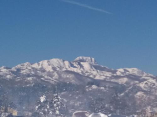 a snow covered mountain with a blue sky in the background at Apartments Mirković in Cetinje