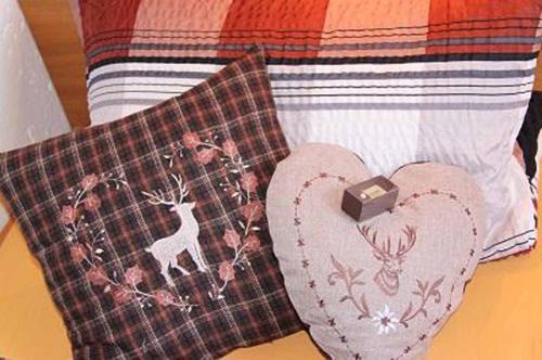 a bed with two pillows and a blanket with a heart at FrongaHOF in Waldkirchen