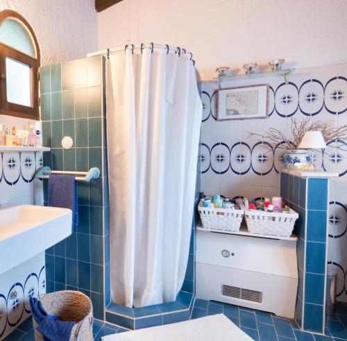 a bathroom with a shower with a white shower curtain at Tritonia in Gaios