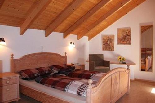 a bedroom with a bed in a room with wooden ceilings at FrongaHOF in Waldkirchen