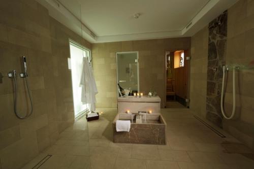 a bathroom with a tub and a sink and a mirror at Romantik Hotel Neuhaus in Iserlohn