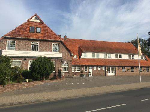 a large brick building on the side of a street at Hotel Wuelfers Gasthaus in Groß Ippener