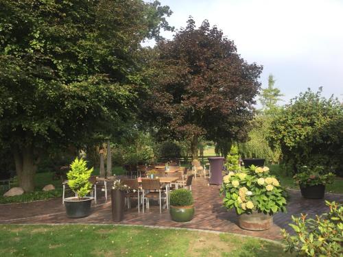 a group of tables and chairs in a garden at Hotel Wuelfers Gasthaus in Groß Ippener
