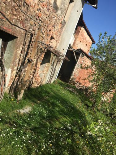 an old brick building with green grass and flowers at I 5 Sensi Country in Brusnengo