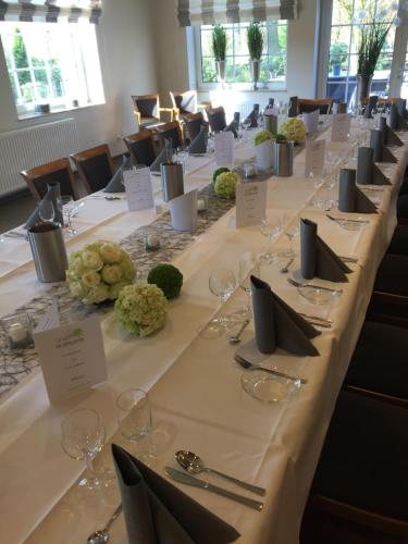 a long table with wine glasses and napkins at Hotel Wuelfers Gasthaus in Groß Ippener
