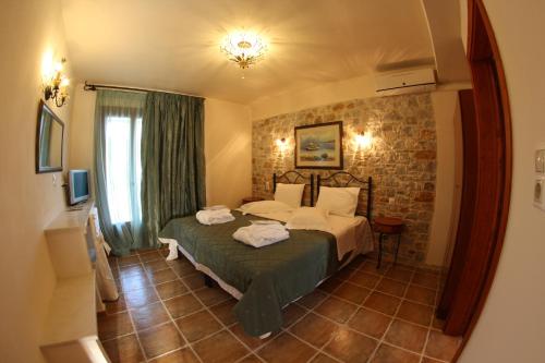 sypialnia z łóżkiem i ceglaną ścianą w obiekcie Skiathos Island Villas w mieście Skiatos
