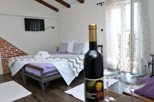 - une bouteille de vin assise sur une table à côté d'une chambre dans l'établissement Apartments Nikolla, à Split