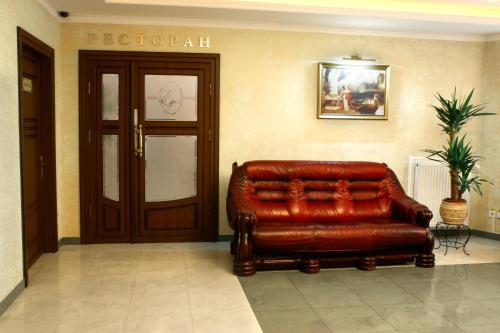 a brown leather couch sitting in a lobby at Edem Hotel Lviv in Lviv
