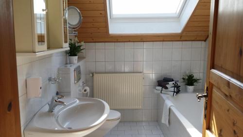 een badkamer met een wastafel, een toilet en een raam bij Gemütliches Apartment in Hattingen