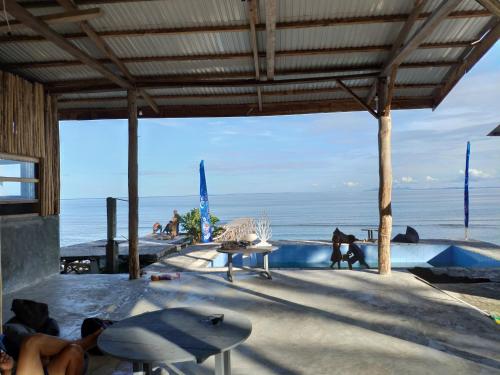 a swimming pool with a view of the beach at Sanctum Una Una Eco Dive Resort in Pulau Unauna