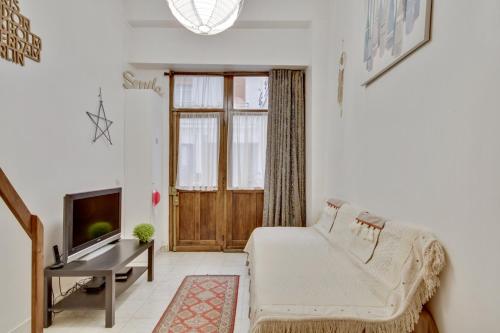 un salon avec un canapé et une télévision dans l'établissement 3 people - Place des Vosges Paris by Weekome, à Paris