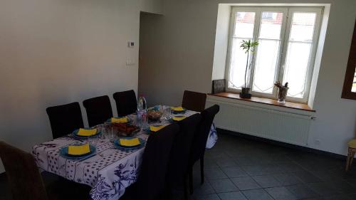 a dining room with a table and chairs and a window at Villa Audresselles in Ambleteuse