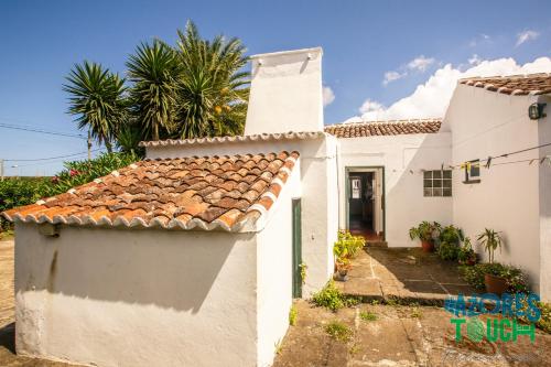 a white house with a tile roof at Hospedaria casa D'Avo in Praia da Vitória