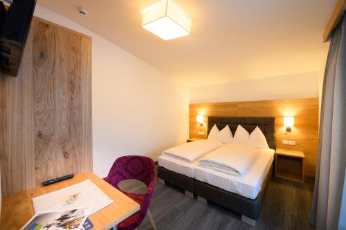 a hotel room with a bed and a desk at Wander- und Familienhotel Erika in Wagrain