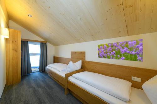 a room with two beds and a painting on the wall at Wander- und Familienhotel Erika in Wagrain