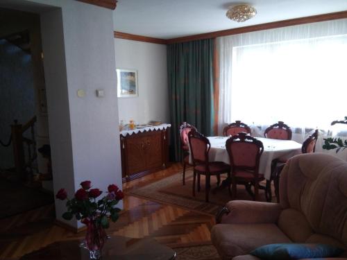 jadalnia ze stołem i krzesłami oraz oknem w obiekcie Home B&B w Kownie