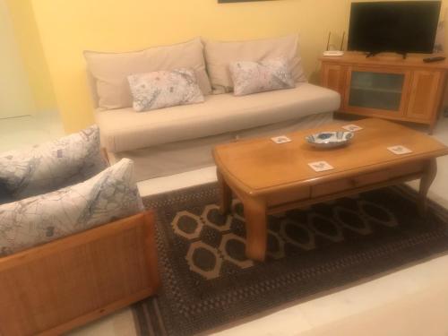 a living room with a couch and a coffee table at Latchi Holiday Flat in Polis Chrysochous