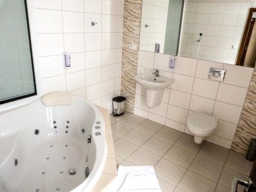 a bathroom with a tub and a sink and a toilet at ELITE HOTEL Nová Dubnica in Nová Dubnica