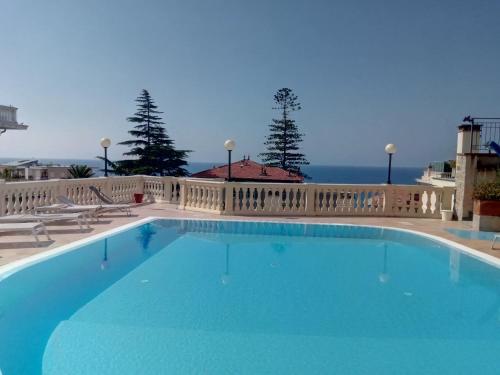 a large swimming pool with the ocean in the background at Residence Dell'Angelo in Ospedaletti