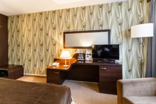 a hotel room with a desk with a television at Hotel Solny in Kołobrzeg