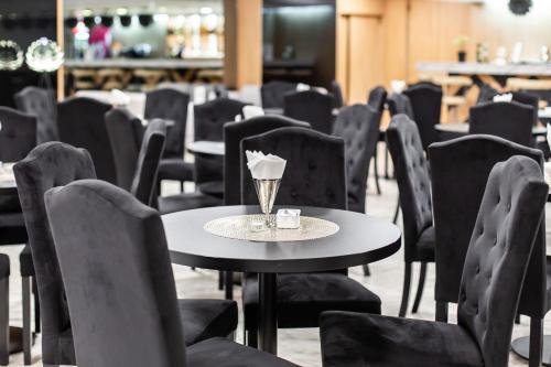 a room with chairs and tables and a table with a cup at Hotel Solny in Kołobrzeg