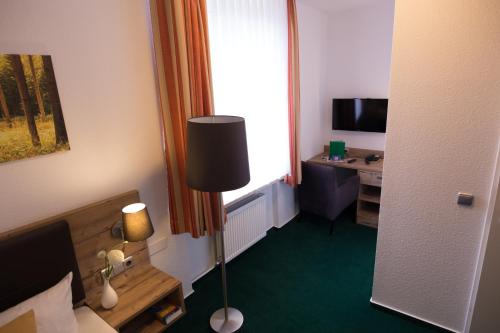a hotel room with a bed and a desk and a window at BSW-Erlebnishotel Festenburg in Clausthal-Zellerfeld