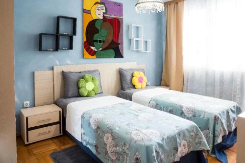 two beds in a room with blue walls at Holiday Apartment on The Seaside, Burgas in Burgas