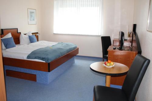 a bedroom with a bed and a desk and a chair at Heppenheimer Hof Hotel in Worms