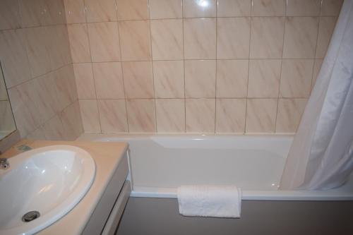 a bathroom with a white tub and a sink at Metropol Hotel in Calais