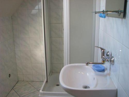 a white sink in a bathroom with a shower at U Ewy i Grzesia in Krzeszna