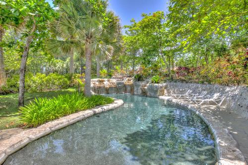 a swimming pool in a yard with palm trees at Sea Horse Ranch in Sosúa