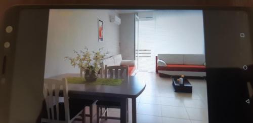 een woonkamer met een tafel en een bank bij Valentino apartments Bouganville Bay Saranda in Sarandë