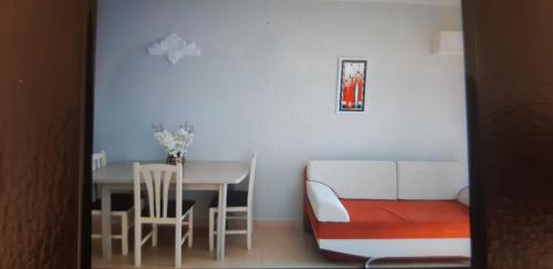 een eetkamer met een tafel, stoelen en een bank bij Valentino apartments Bouganville Bay Saranda in Sarandë