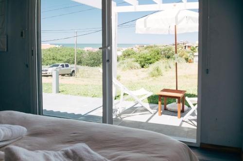 a bedroom with a bed and a chair and an umbrella at Kanaloah Lodge & Cabins in Punta Del Diablo