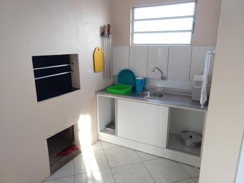 a small kitchen with a sink and a counter at Casa para verão em Balneário Gaivota in Balneário Gaivotas