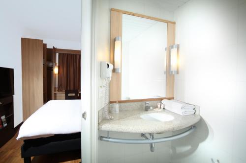 a bathroom with a sink, mirror, and bathtub at ibis Santiago Providencia in Santiago