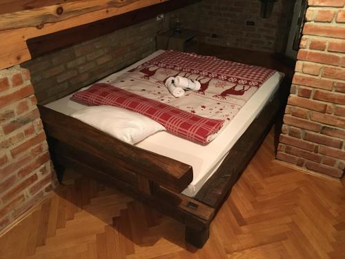 a bed in a room with a brick wall at Matanovi Dvori in Slavonski Brod
