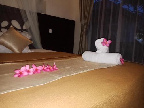 a hotel room with a towel made out of flowers on a bed at ZiFa Mandalika in Kuta Lombok