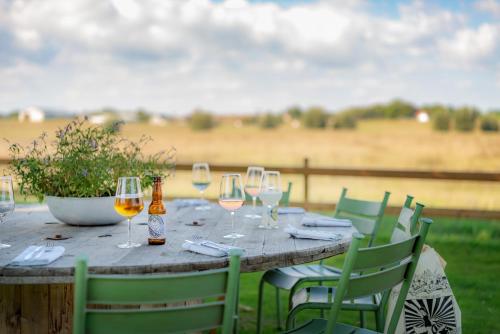 a wooden table with wine glasses on a field at Hotell Mossbylund in Abbekås