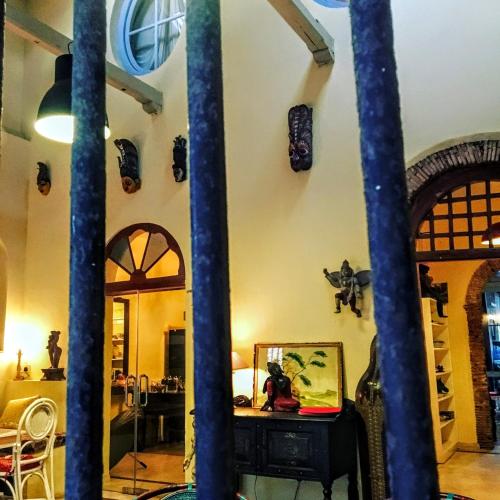 a living room with a table and some columns at LE JARDIN DU FORT - GALLE in Galle
