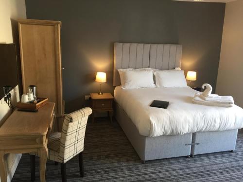 a hotel room with a bed and a desk and a chair at The Bell Inn in Worcester