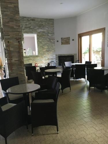 a dining room with tables and chairs and a fireplace at Albergo Breglia in Plesio