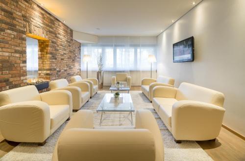 a waiting room with white couches and a brick wall at Best Western Hotel Trier City in Trier