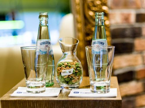 two bottles and two glasses on a wooden table at Best Western Hotel Trier City in Trier