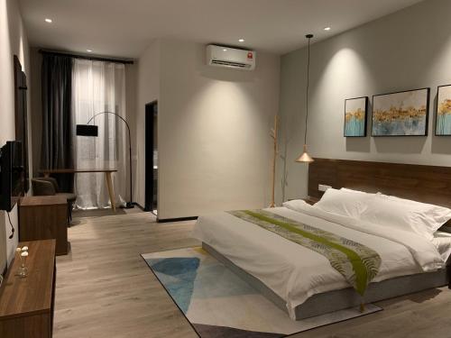 a bedroom with a large bed and a tv at Cloud9 Holiday Cottages in Pantai Cenang