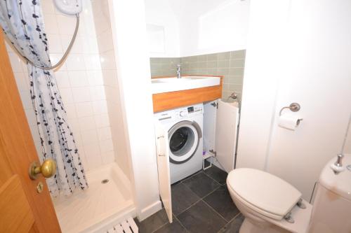 a bathroom with a toilet and a washing machine at 20 Bellevue Road in Ryde