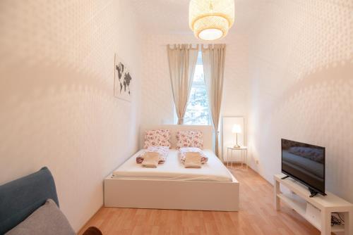 a white room with a bed and a television at Vienna Living Apartments - Schnirchgasse in Vienna