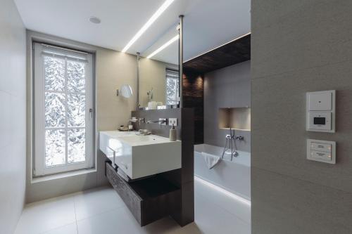 łazienka z białą umywalką i oknem w obiekcie Mooser Hotel w mieście Sankt Anton am Arlberg